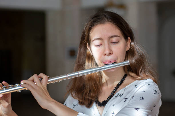 istock A beautiful woman posing while playing on a flute 1064843954