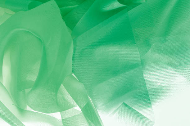 istock Texture, background, pattern. The texture of the silk fabric is green. Silk fabric is transparent. Fabric or liquid wave illustration of wavy creases of silk satin texture or velvet material 1064850206