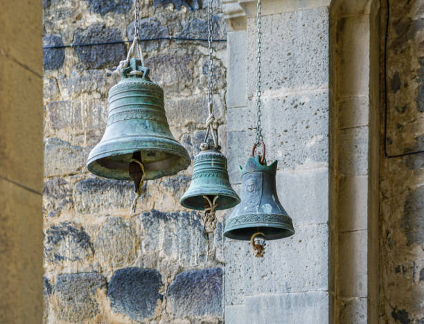 istock three church bells of small, medium and large size hanging in chains 1064865898