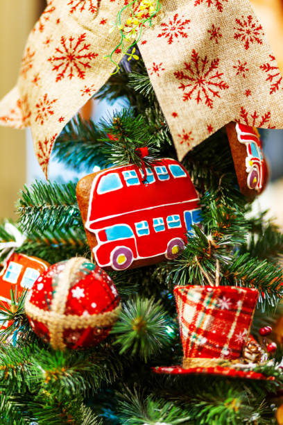istock Fir tree decorated with gingerbread in shape of double decker bus and fabric balls for Christmas and New Year celebration. 1064866654