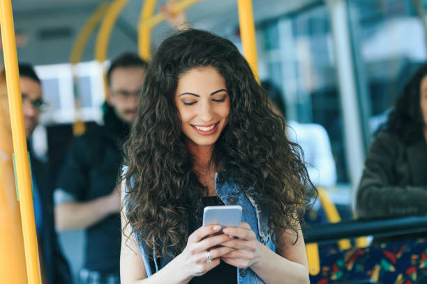 istock Smiling woman text messaging in public transport 1064869084