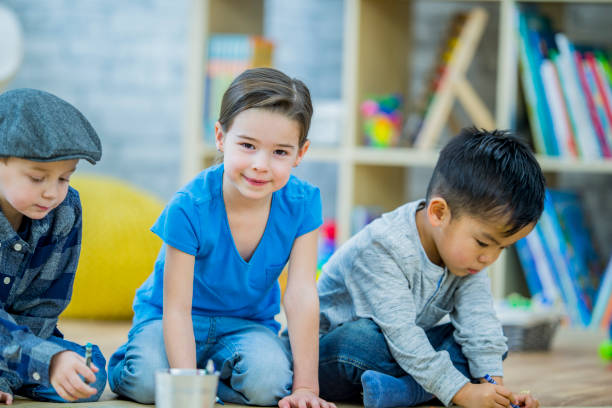 istock Three happy kindergarten kids drawing 1064869274