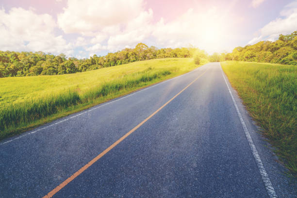 istock Highway road through green grass under blue sky.Highway road through green grass under blue sky. 1064872902