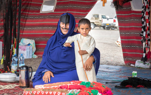 Ibri, Oman, 28th April 2018: bedouin woman with her kid in a tent, selling handcraft items