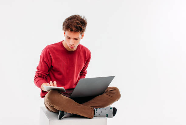 étudiant d’adolescent avec un travail à l’ordinateur portable et tablette sur dos blanc - isolated on white contemporary red white photos et images de collection