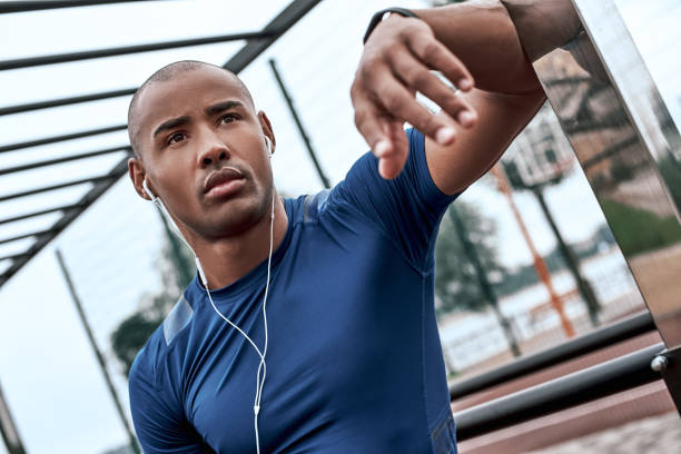 istock Young african man at the open air gym is resting after doing exercises 1064880624