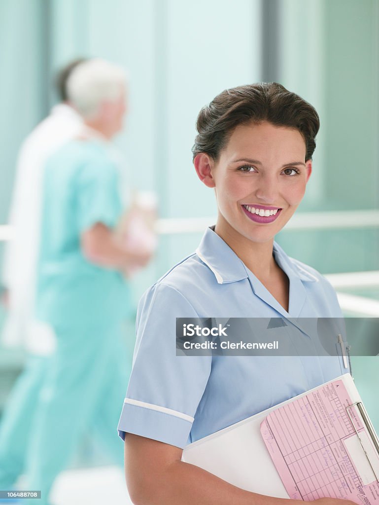 Szczęśliwa kobieta pielęgniarki z lekarzy w tle Portret - Zbiór zdjęć royalty-free (25-29 lat)