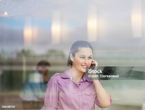 Mulher De Negócios Fala No Telefone Móvel Com O Seu Colega De Trabalho - Fotografias de stock e mais imagens de 25-29 Anos