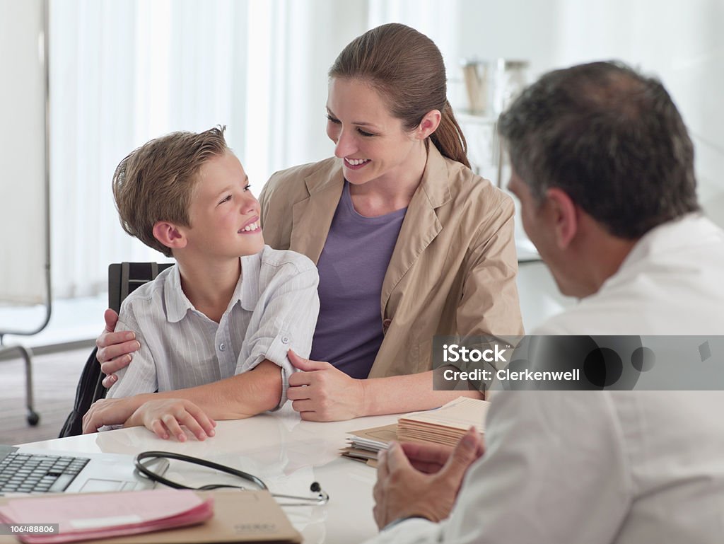 Sorridente mãe e filho (10-11) com médico na clínica - Royalty-free Criança Foto de stock