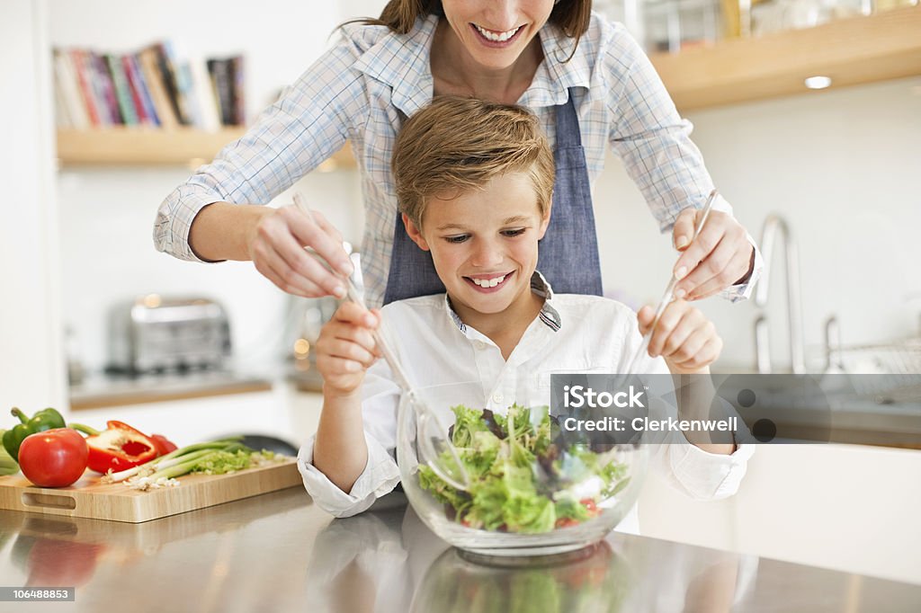 Madre e figlio (10-11) miscelazione Insalata di verdure in cucina - Foto stock royalty-free di 10-11 anni