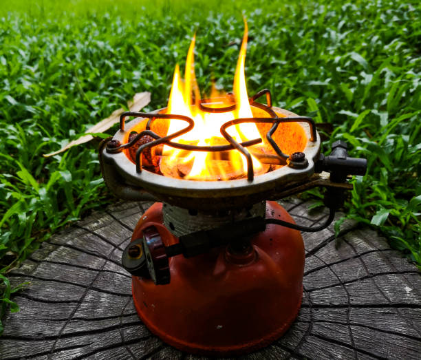 Old camping stove Was left on a green lawn.
