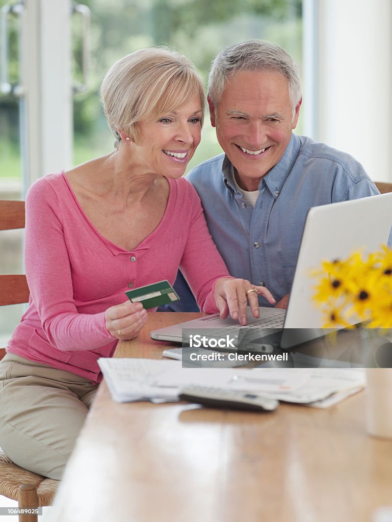 Casal de compras on-line no computador portátil em casa - Royalty-free 55-59 anos Foto de stock