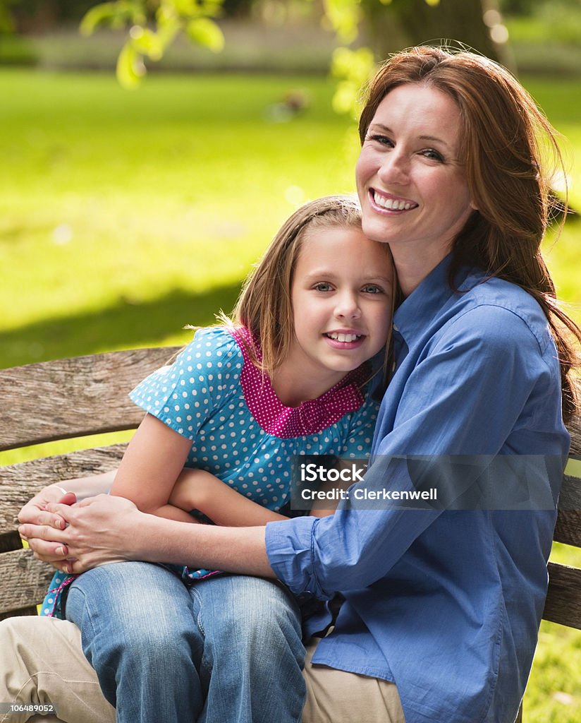 Sorridente madre con figlia (8-9) sedersi sulla panca - Foto stock royalty-free di 35-39 anni