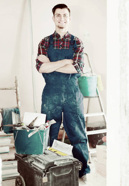 istock professional smiling builder standing in repairable room 1064900964