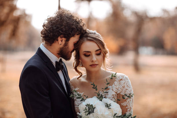 istock Bride and groom embracing in the park 1064904614