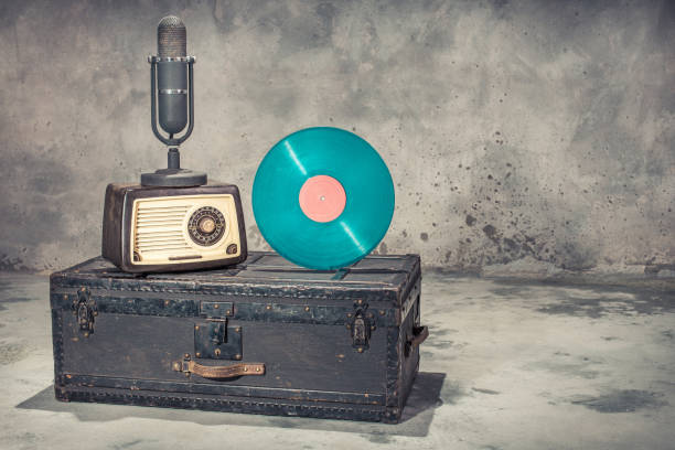 retro radio from 60s, studio microphone from 50s, and blue vinyl disc record circa 70s on old aged classic travel trunk with leather handles. vintage style filtered photo - trunk luggage old fashioned retro revival imagens e fotografias de stock