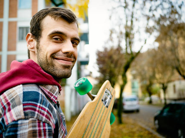 istock Portrait of young man with longboard 1064909268