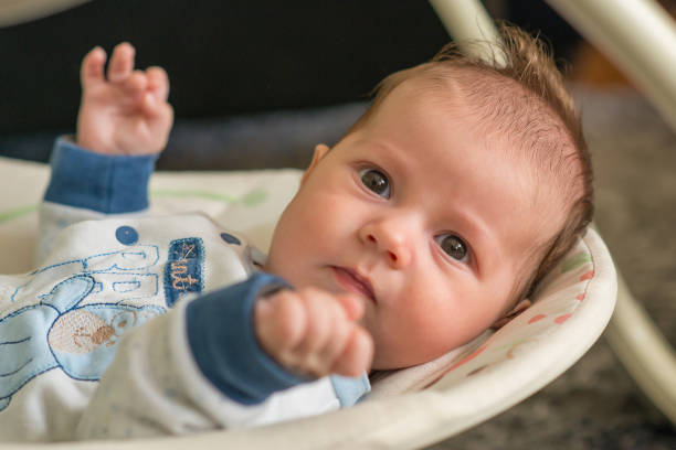istock The newborn lies on swing automatic electrical chair and enjoys it 1064909856