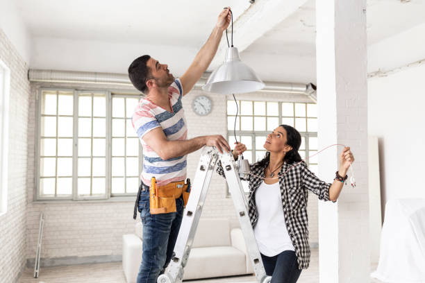 istock Couple making renovations, changing lighting equipment 1064909894
