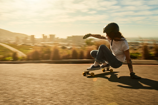 Shot of a young woman out on her skateboard