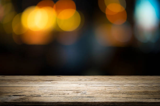 istock Empty wooden table platform and bokeh at night 1064912492