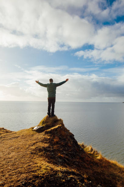 istock Man looking and celebrating sunrise and landscape 1064914230