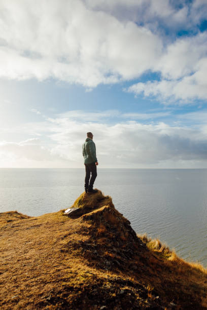istock Man looking and celebrating sunrise and landscape 1064914668