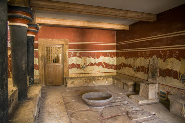 Palace of Knossos, throne room. Walls decorated with ancient frescoes. Royal throne in front of a mysterious bowl. Palace of Knossos, throne room. Walls decorated with ancient frescoes. Royal throne in front of a mysterious bowl. knossos photos stock pictures, royalty-free photos & images