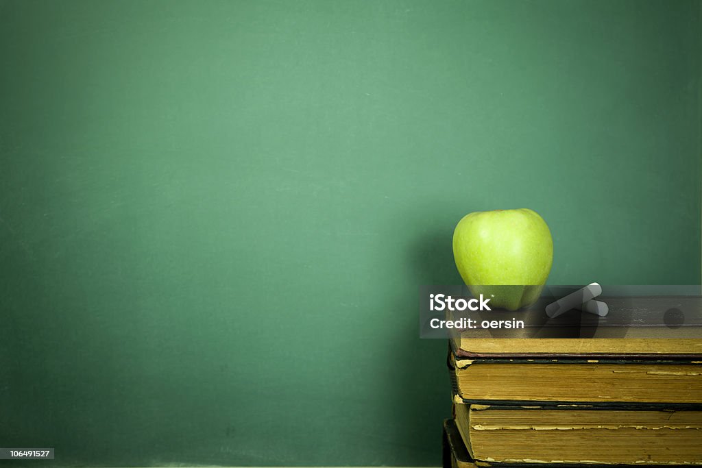 Green apple and chalk sitting on education books Education concept, toned and soft focus image Apple - Fruit Stock Photo