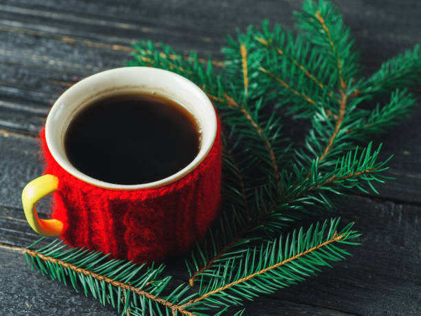 istock Mug of hot coffee on a dark wooden background with tree branches 1064917664
