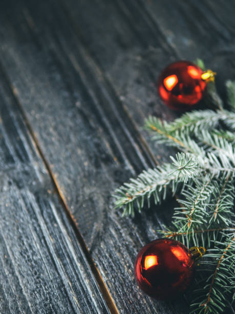 istock Christmas dark background with red Christmas balls and snow tree branches 1064917746
