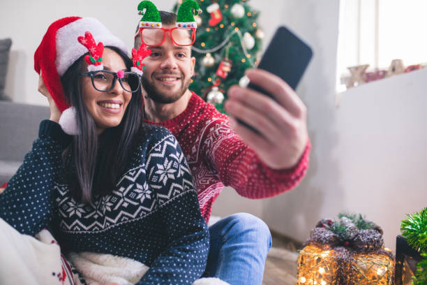 istock Young man and woman taking selfie for Christmas 1064921604