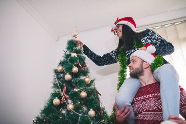 istock Cute, young couple decorating a Christmas tree 1064923426