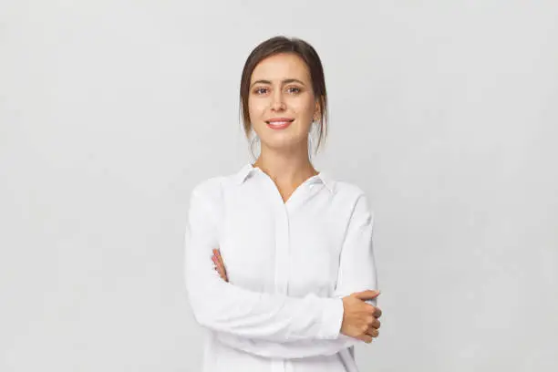 Amazing and cheerful smiling brunette in white shirt studio shot, isolated on white