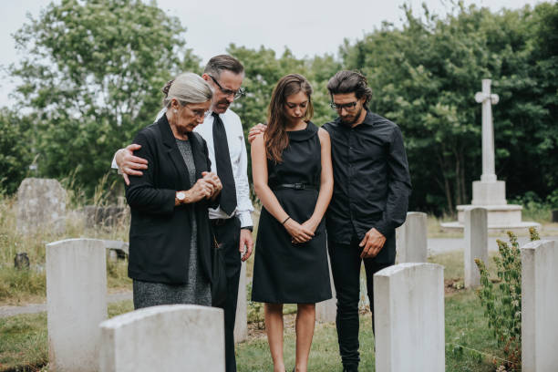 family giving their last goodbyes at the cemetery - place of burial imagens e fotografias de stock