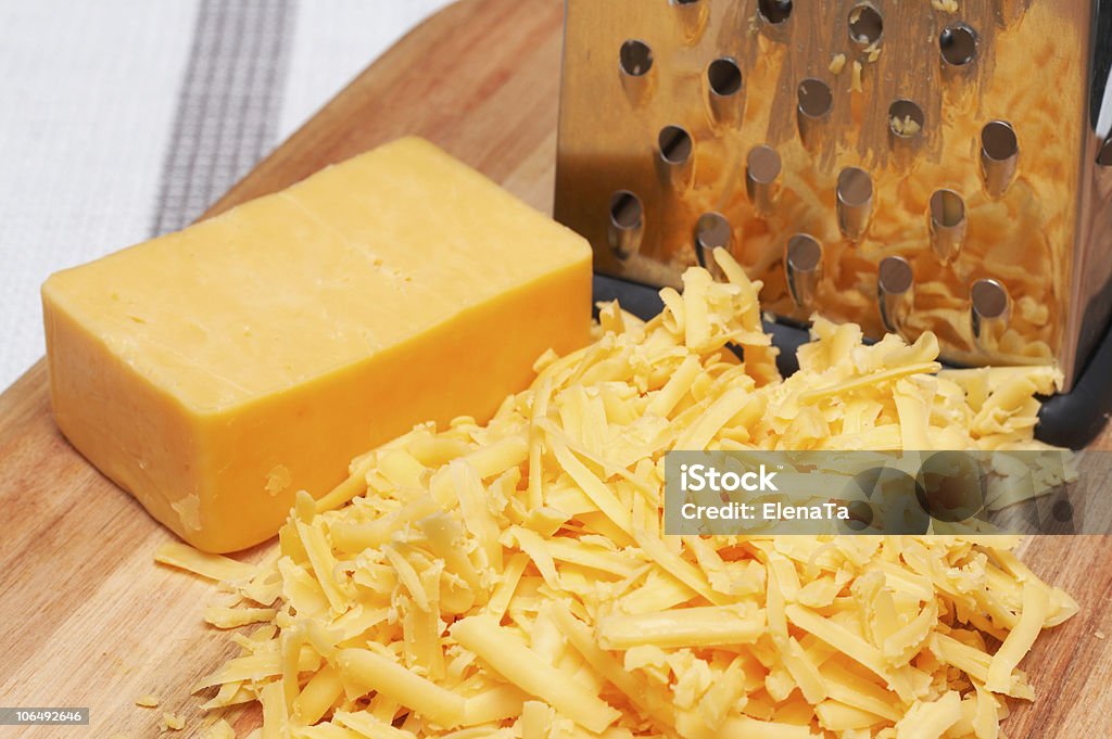 Grated cheddar cheese on wooden board  Cheddar Cheese Stock Photo