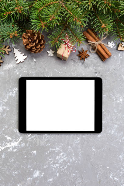 istock Digital tablet mock up with rustic Christmas gray cement background decorations for app presentation. top view with copy space 1064932080