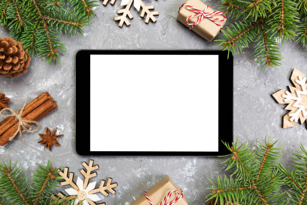 istock Digital tablet mock up with rustic Christmas gray cement background decorations for app presentation. top view with copy space 1064932100