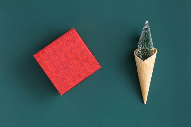 minimalista fondo de navidad con abeto rojo y árbol de regalo caja de juguete sobre fondo verde. concepto de año nuevo. vista plana laica y superior. - mano sobre cadera fotografías e imágenes de stock
