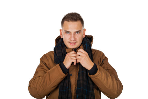 Handsome young man wearing a light brown winter parka jacket - smiling to the camera on isolated background