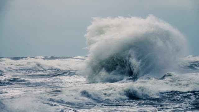 High wave breaking on the rocks of the coastline. Extremely Big Wave crushing coast , Large Ocean Beautiful Wave. Super Slow Motion.