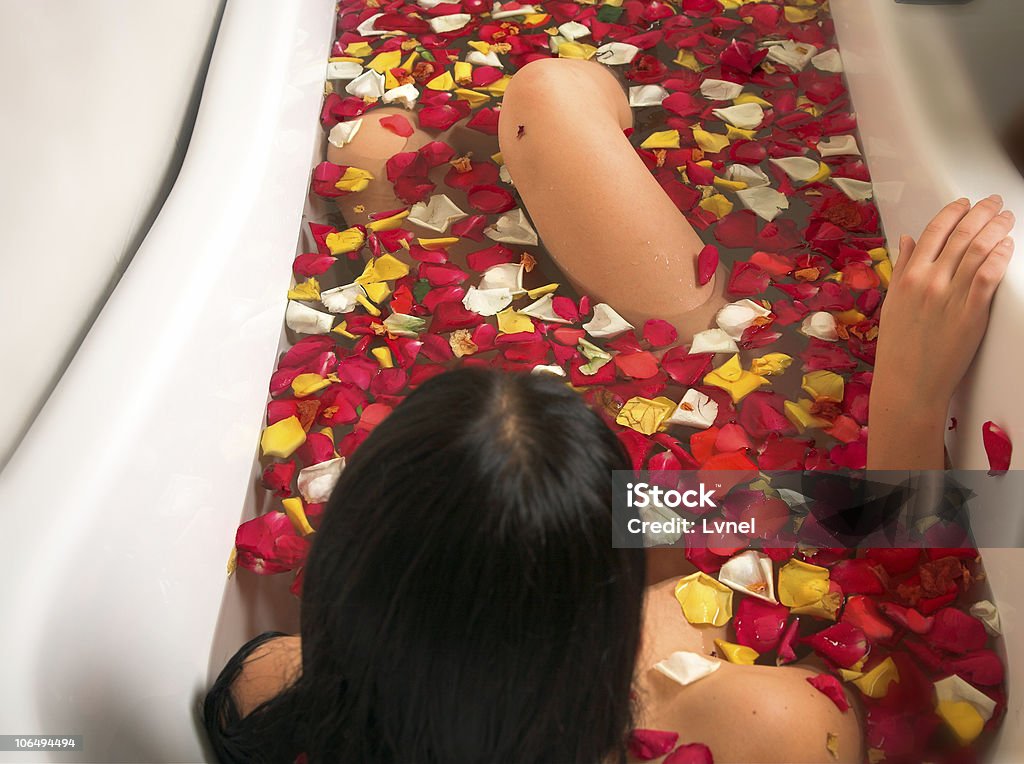 Mulher em um banho com pétalas de rosas - Foto de stock de 20 Anos royalty-free