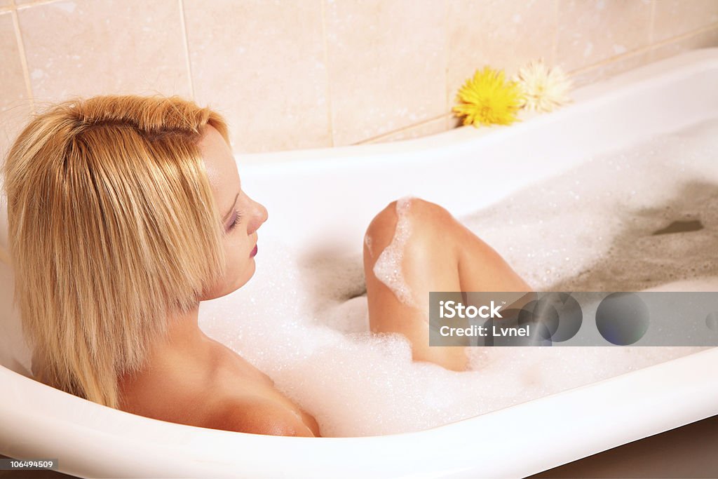 若い金髪女性は泡のバスルームをお楽しみいただけます。 - びしょ濡れのロイヤリティフリーストックフォト