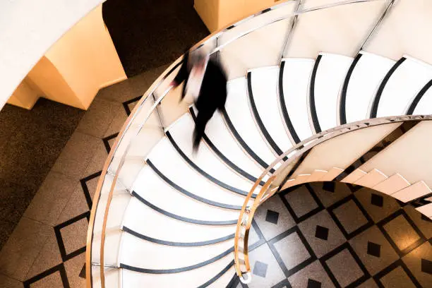 Photo of Motion Blur of Speeding Businessman on Abstract Spiral Staircase