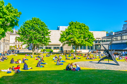 Dublin, Ireland, May 9, 2017: Students are having a picnic on a field inside of the trinity college in Dublin, Ireland