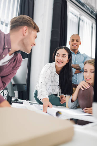 istock happy young business people smiling while working together in open space office 1064948492