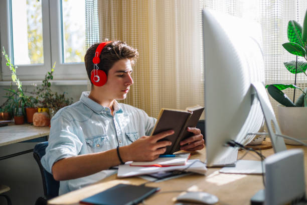 istock Teenage boy reading the book 1064948882