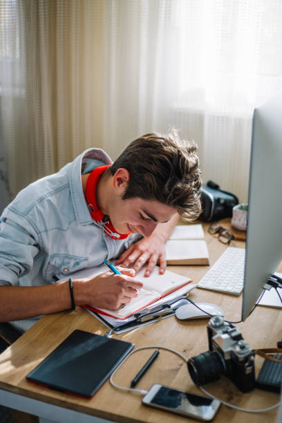 Teenage boy doing homework stock photo