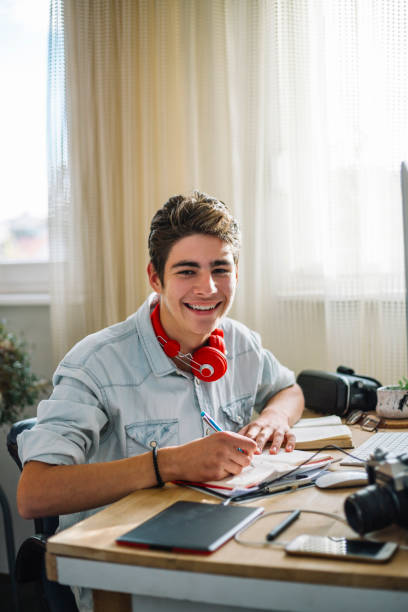 istock Smiling teenager doing homework 1064950404