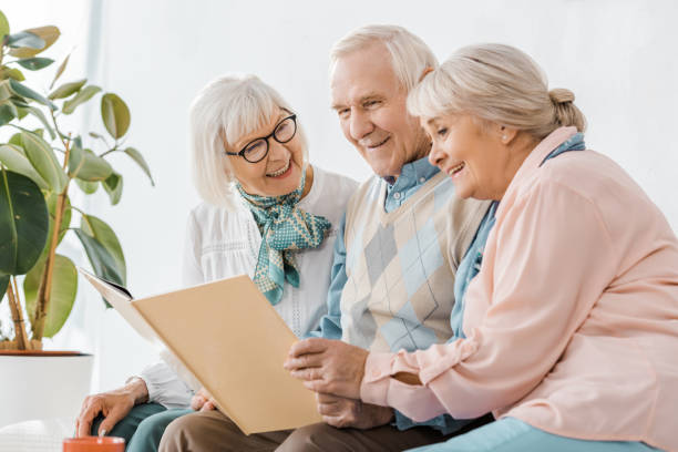 istock senior smiling people reading book together in nursing home 1064954930